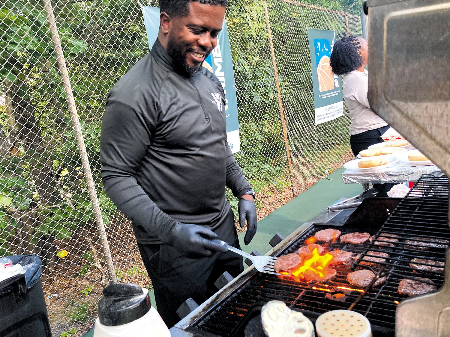 HEATING UP: Greater Providence YMCA COO Kobi Dennis serves up some burgers for fans watching the games.